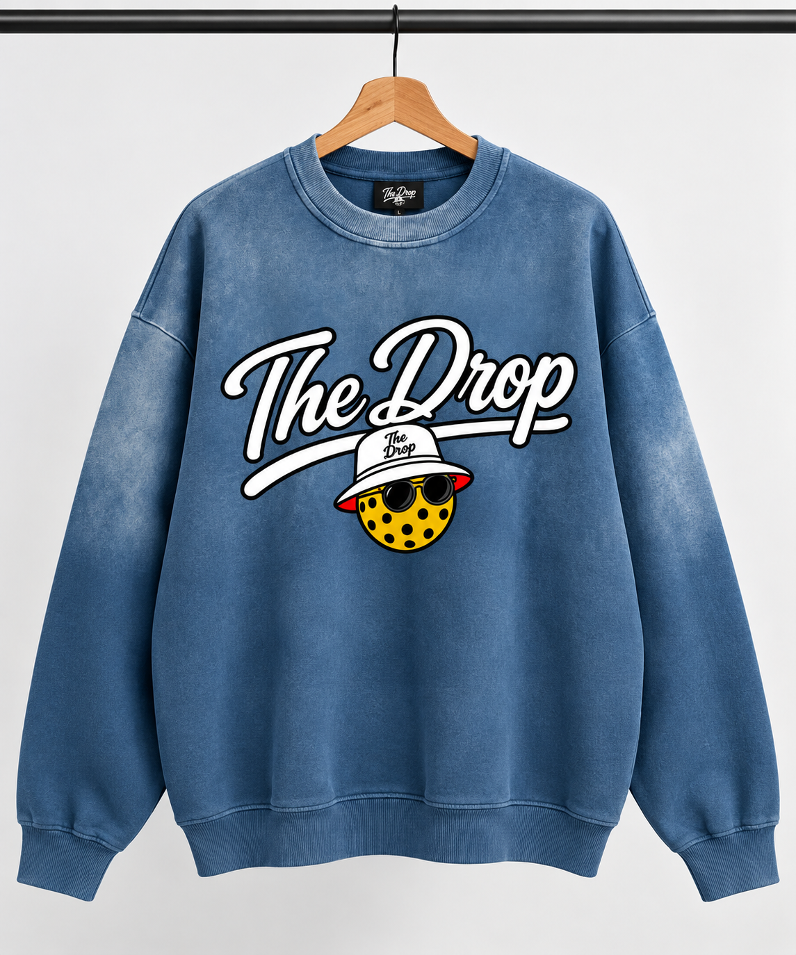The Drop Blue Crewneck on a wooden hanger, front view
